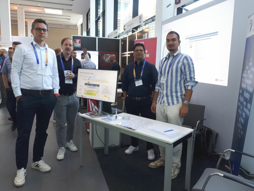 A group shot of our team in front of the booth, proudly showcasing our presence at Siemens PLM Connection 2025.