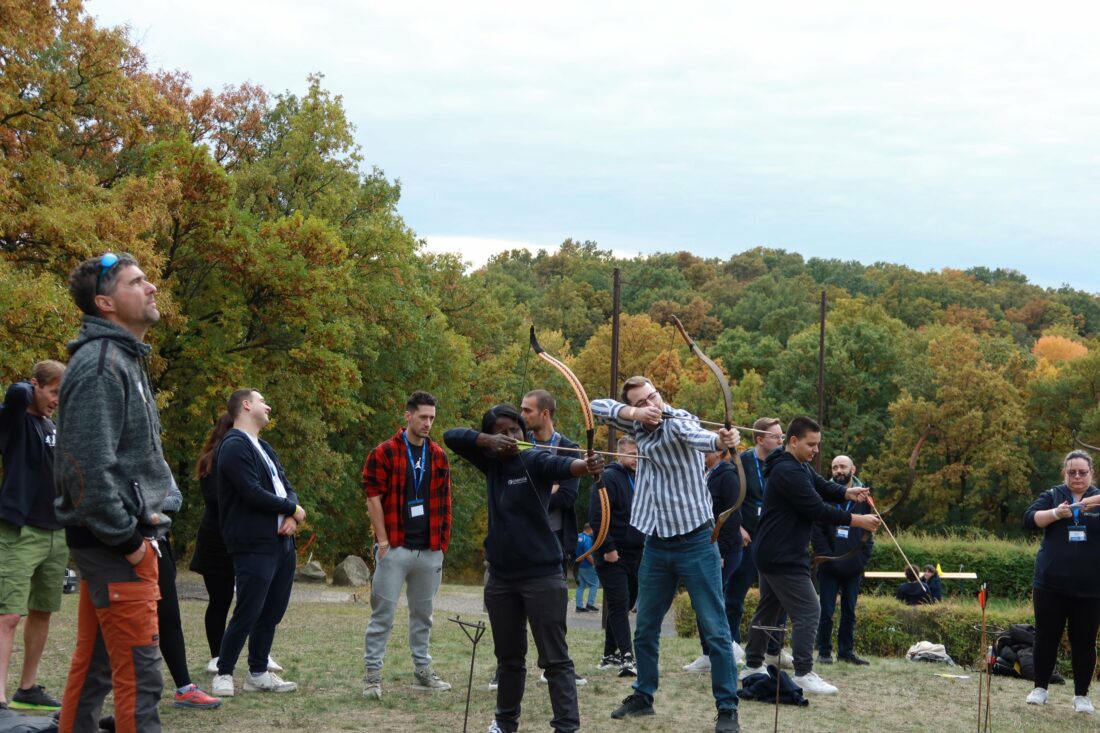 Team aiming at archery targets during outdoor challenge activity