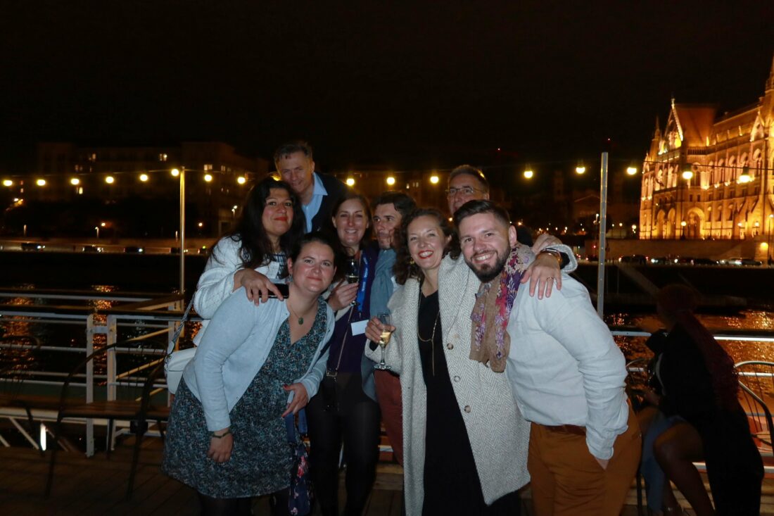 Group of teammates laughing and chatting on the boat during sunset